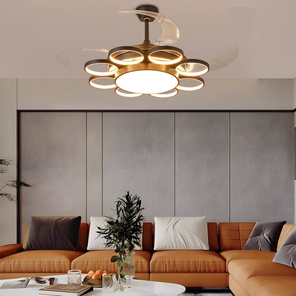 Modern gold ceiling fan with light, illuminating a cozy living room with a sofa.