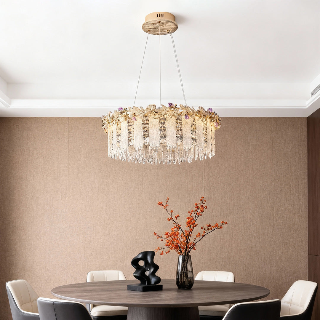 Modern gold chandelier crystal above dining table creating soft ambient light.