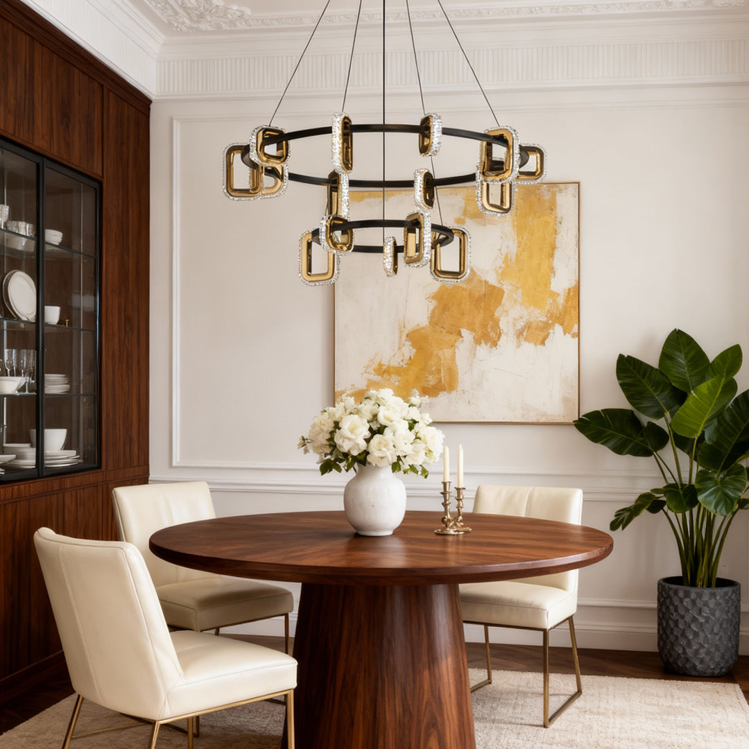 Modern gold chandeliers providing focal lighting in dining room with round wood table and vibrant colorful wall art