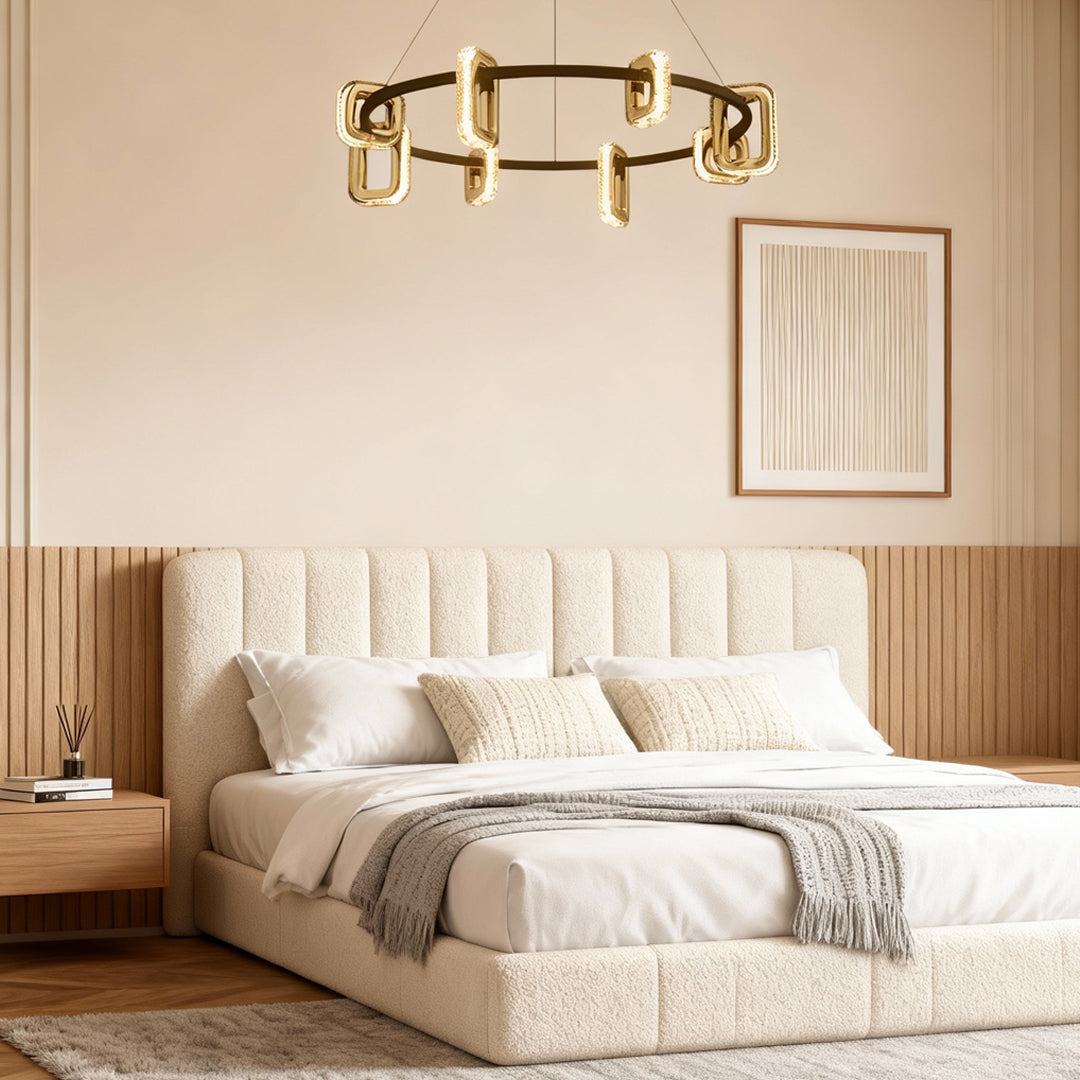 Modern gold chandeliers creating warm ambiance in elegant bedroom with cream tufted bed and neutral color palette