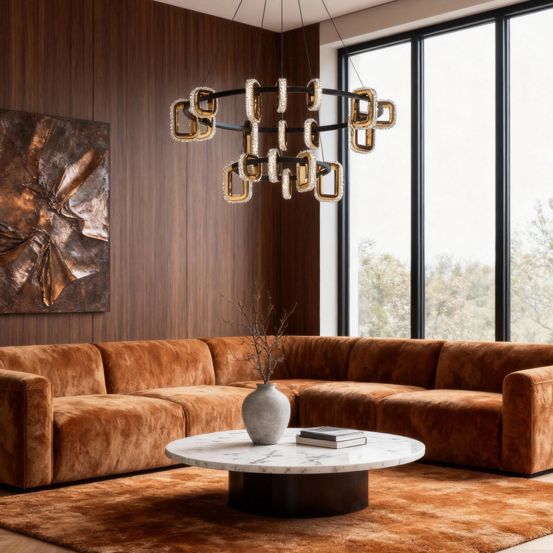 Modern gold chandeliers illuminating living room with cognac leather sofa and rich wood paneled accent wall