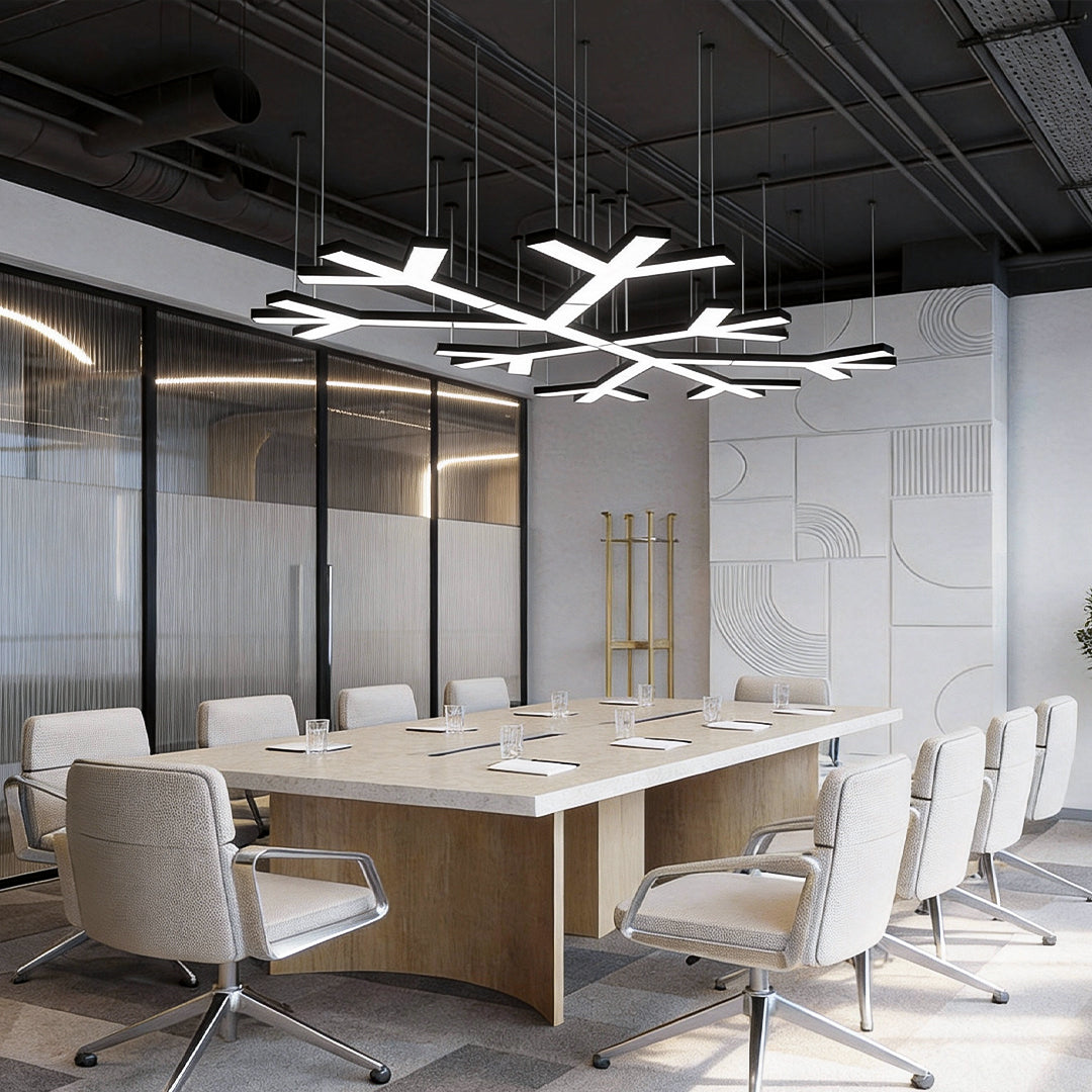 Modern industrial chandelier lighting a large boardroom, showcasing sharp geometric lines and suspended LED elements for even illumination.
