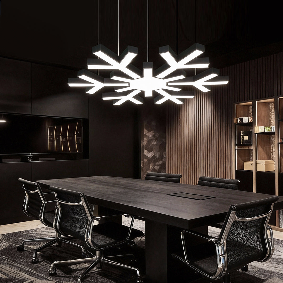 Modern industrial chandelier above a dark-toned conference table, delivering dramatic contrast and a strong architectural lighting statement.