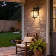 Modern lantern outdoor wall light illuminating a cozy patio seating area with warm ambient lighting.