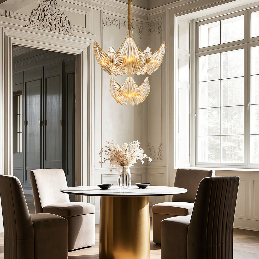 Modern large chandeliers lighting contemporary dining area with brass table and designer chairs
