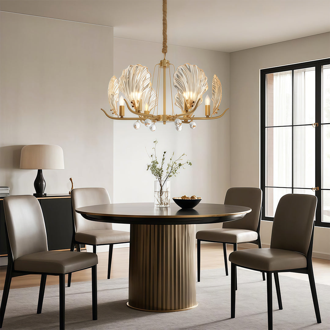 Modern luxury chandeliers illuminating dining area with fluted round table and designer chairs
