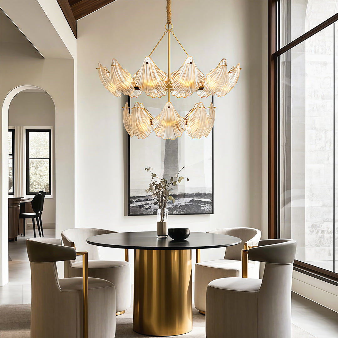 Modern large chandeliers creating focal point in elegant dining space with brass pedestal table