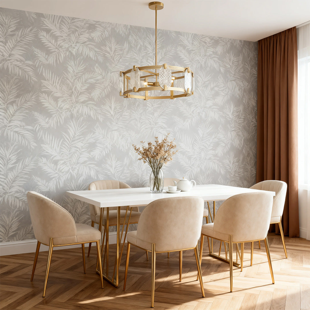 Modern round glass chandelier suspended in a dining area with leaf-patterned wallpaper and gold-accented velvet chairs.