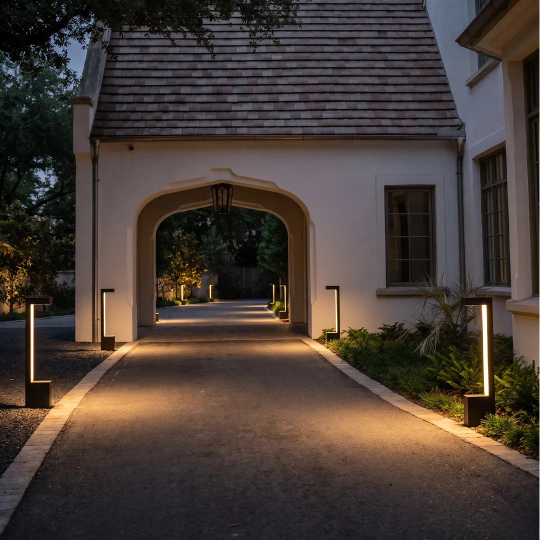 Modern LED bollard lights along covered driveway entrance with warm lighting