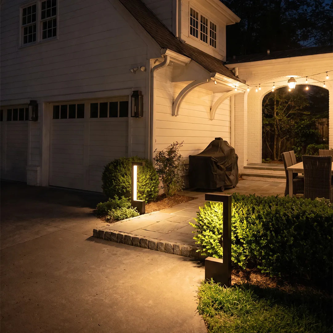 Modern LED bollard lights illuminating garage entrance and landscaped driveway