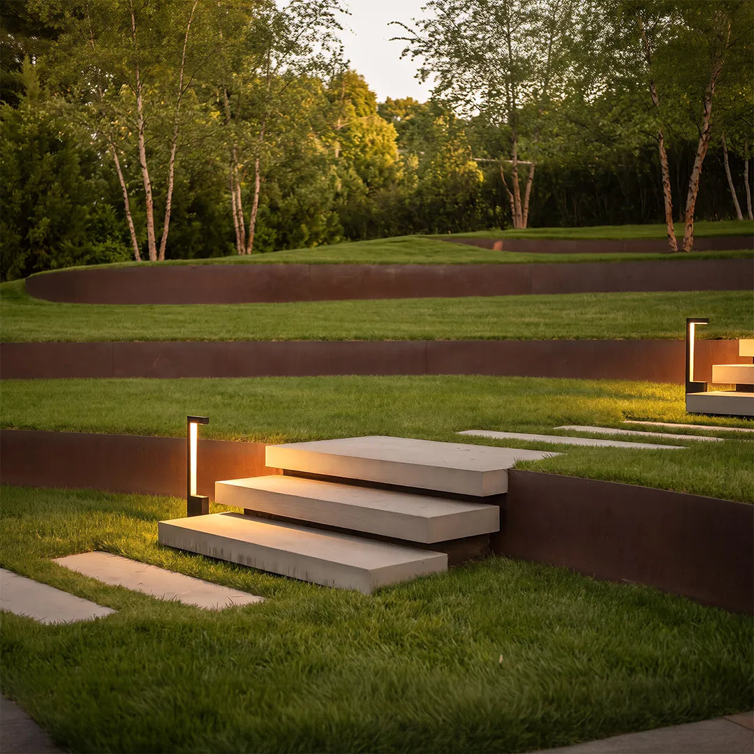 Modern LED bollard lights illuminating outdoor landscape steps and lawn