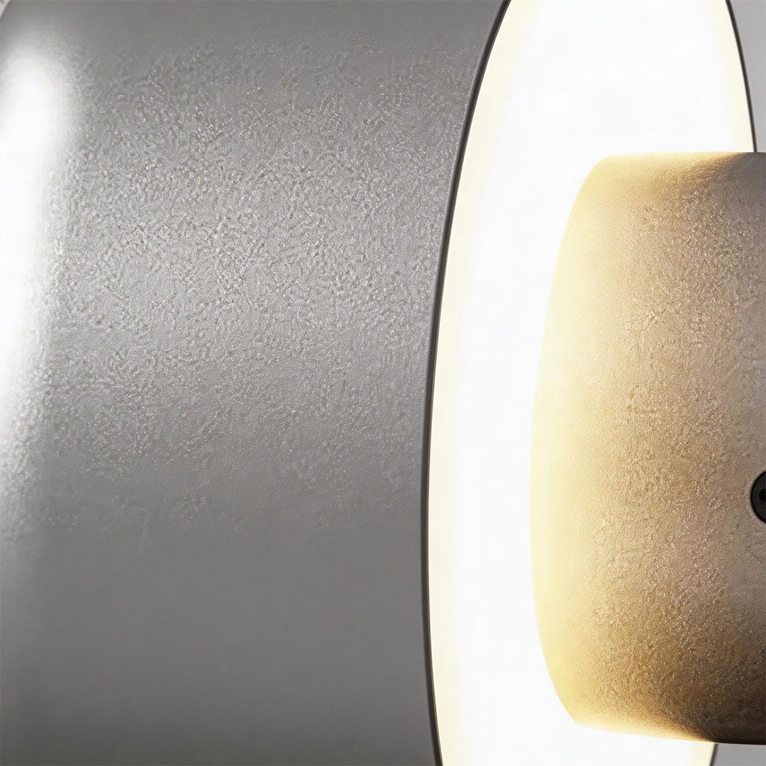 Modern LED outdoor wall light with a black finish and illuminated ring for ambient lighting.