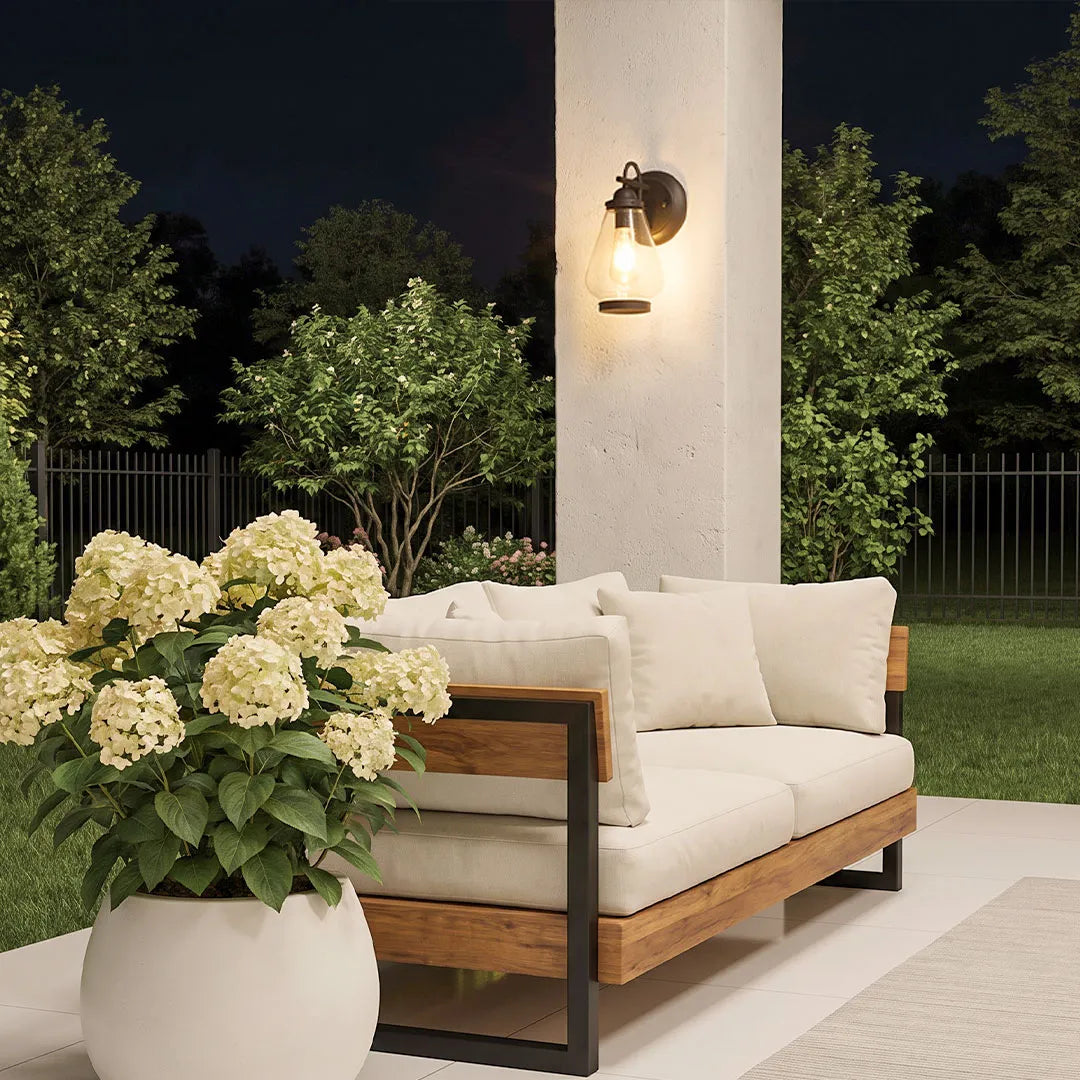 Modern LED outdoor wall light casting a focused beam beside an exterior doorway.