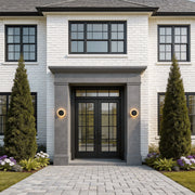 Modern LED outdoor wall lights installed on either side of a glass door in a contemporary home.