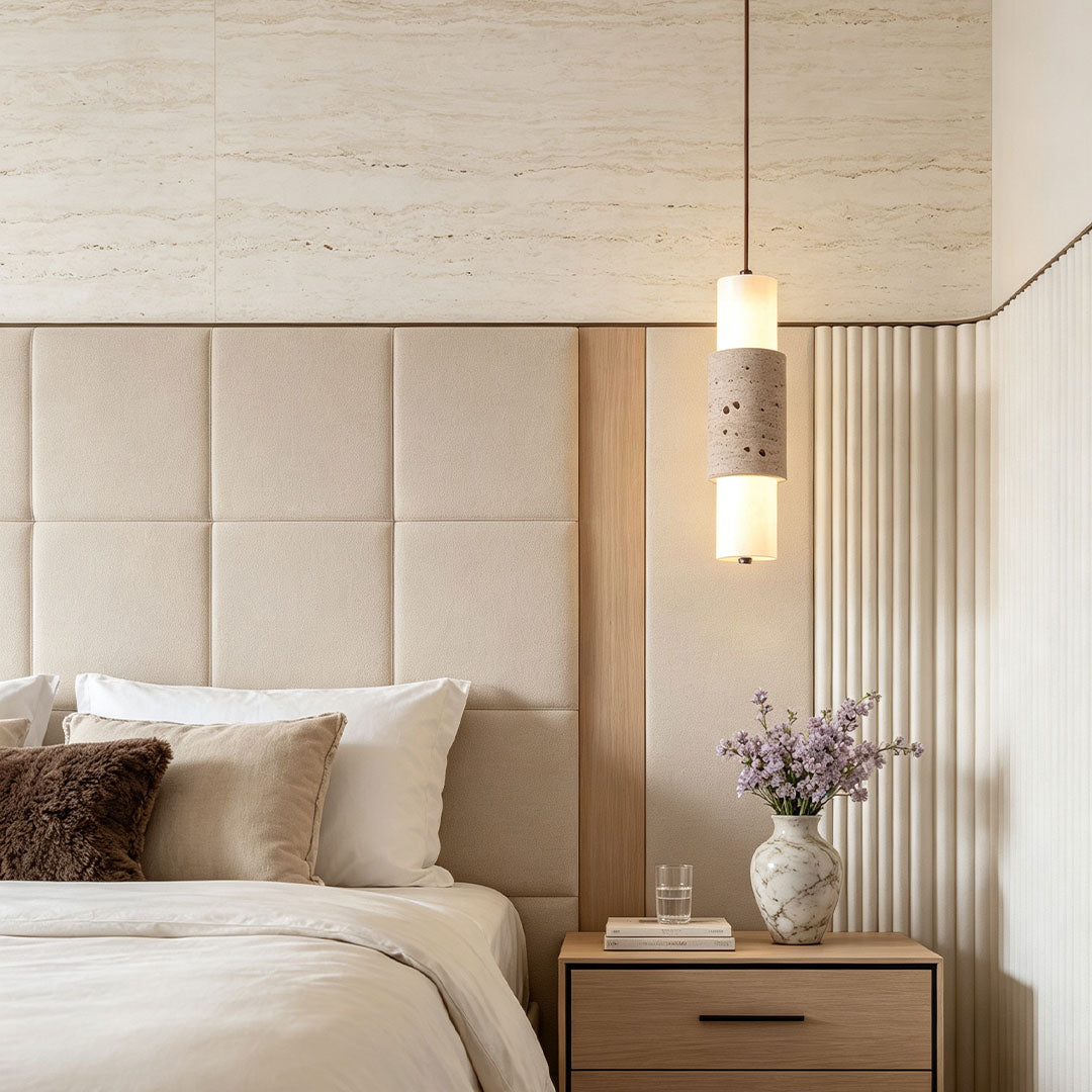 Modern LED pendant lights installed above a bedside table with textured stone and warm light.