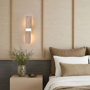 Modern LED wall lights installed beside a bed with warm illumination and natural interior finishes.