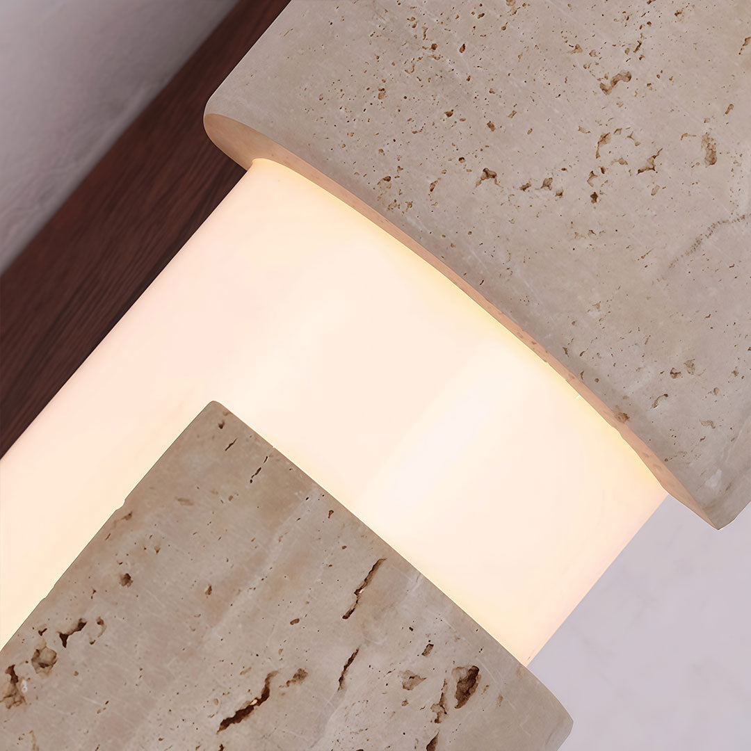 Close-up of modern LED wall lights showing the glowing diffuser between textured stone sections.