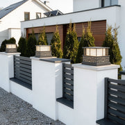 Modern light pillar for home with a sleek design, installed on a white fence beside a contemporary house.
