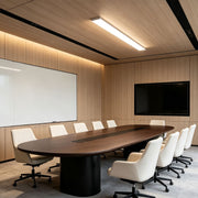 Modern linear ceiling light installed above a contemporary conference room table.