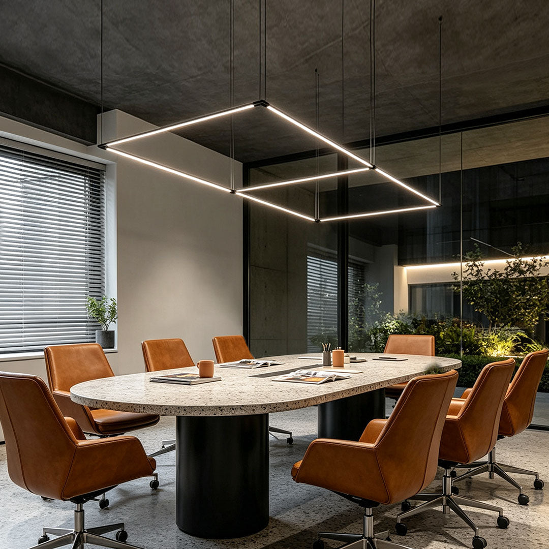 Modern linear gold pendant light installed above a contemporary conference table.