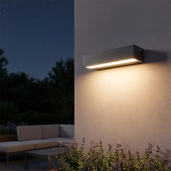 Modern linear outdoor wall light illuminating a patio at night