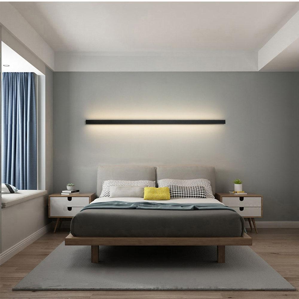 Modern linear outdoor wall sconce with soft glow, mounted in a contemporary bedroom for stylish indoor-outdoor transition.