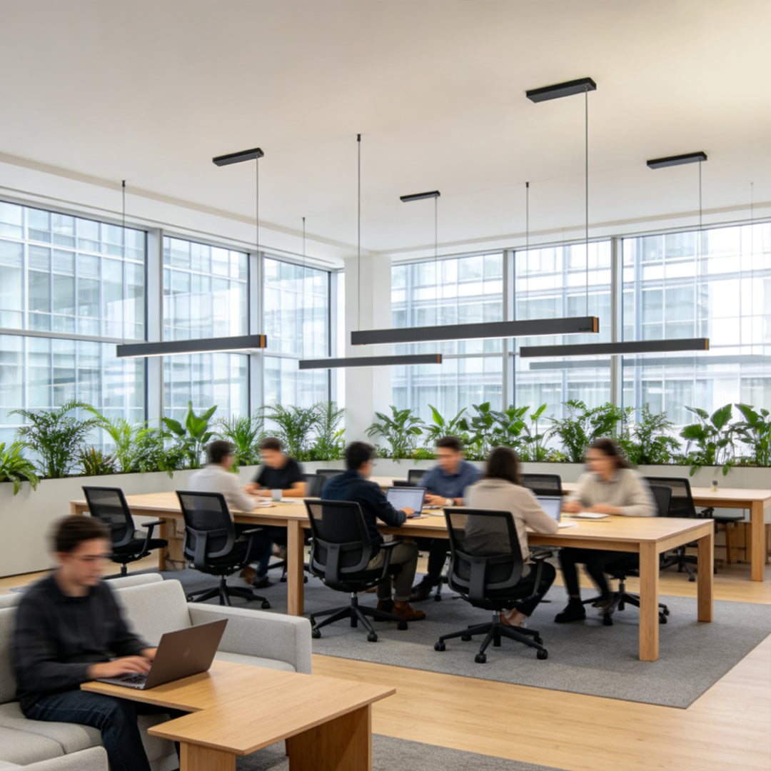 Modern linear pendant light fixtures creating bright illumination in a coworking workspace.
