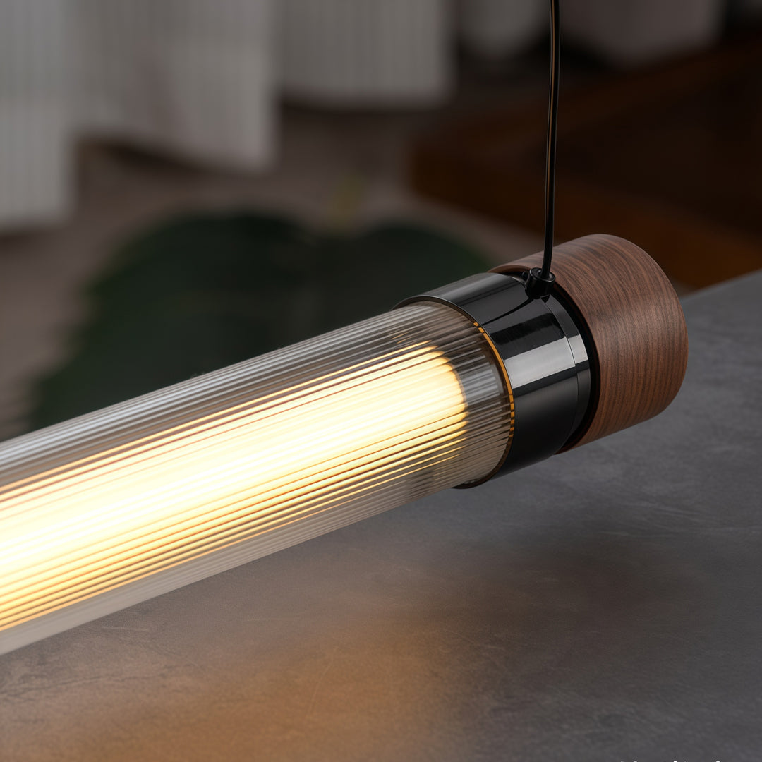Close-up of modern linear pendant lighting featuring a textured diffuser and premium wood accent details.