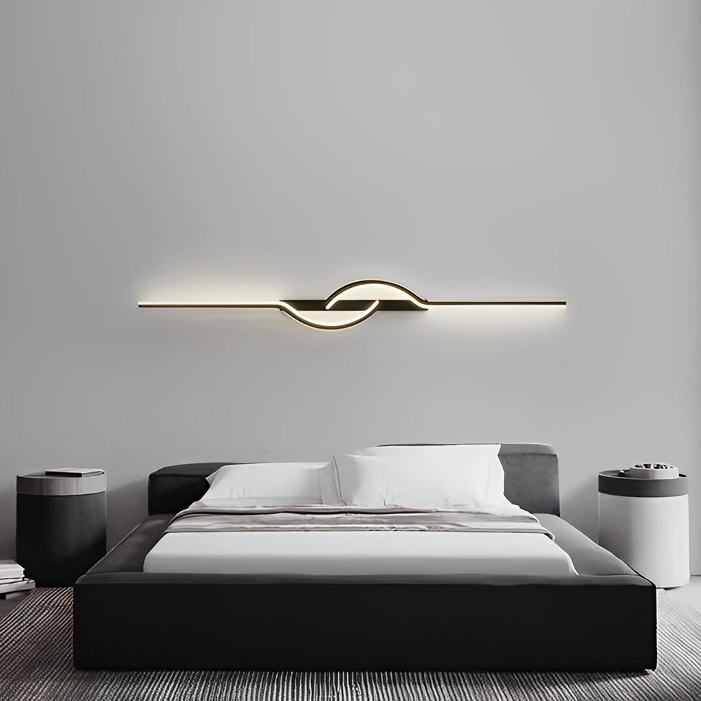 Horizontal modern linear wall sconce centered above a minimalist bed headboard.