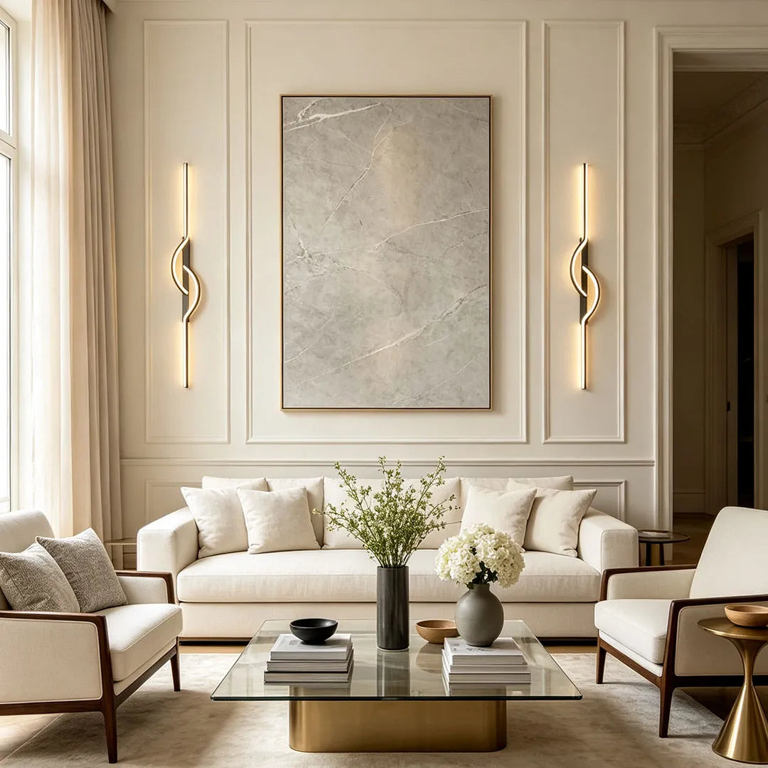 Modern linear wall sconces flanking artwork in a contemporary living room with a cream sofa and coffee table.