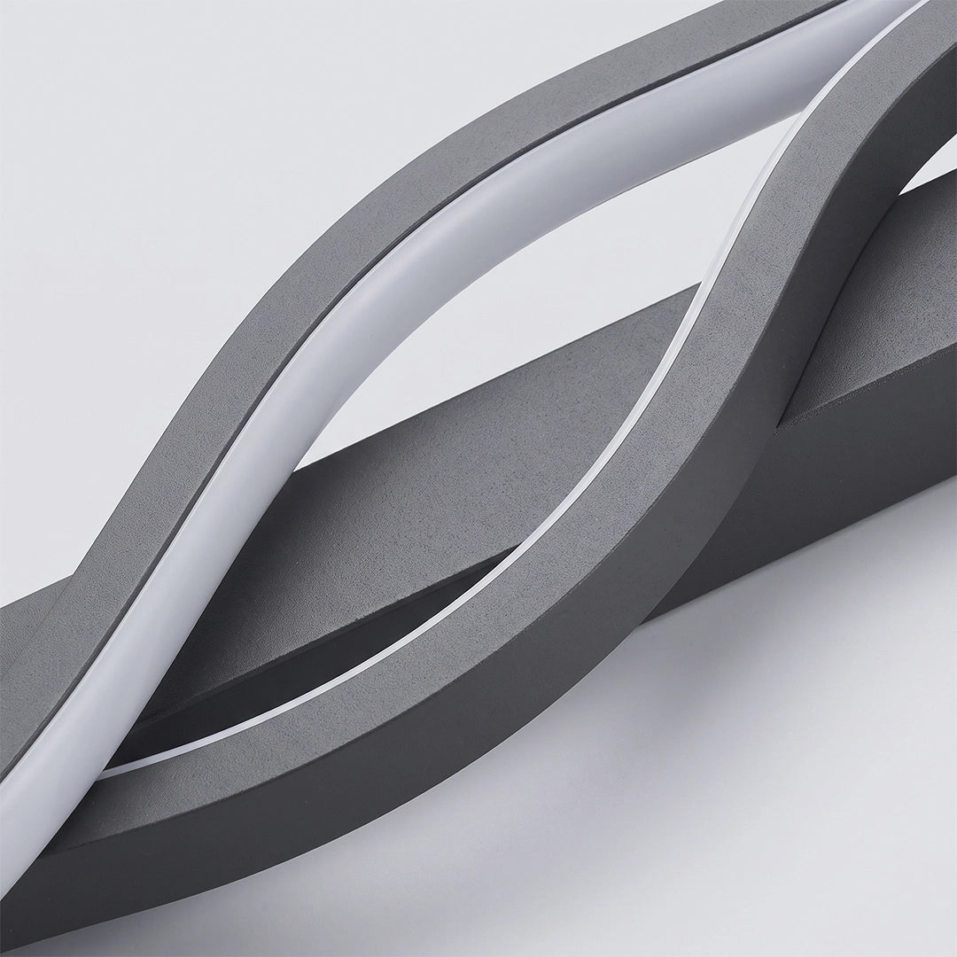 Close-up of the curved black frame and integrated white LED strip on a modern linear wall sconce.