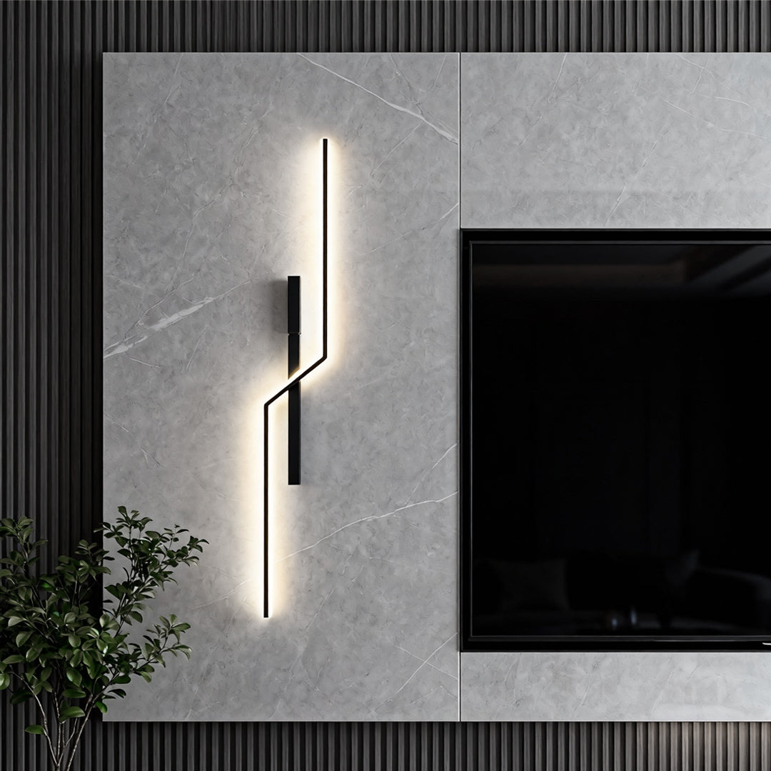 Slim modern linear wall sconce used as vertical decorative lighting beside TV in modern living room.
