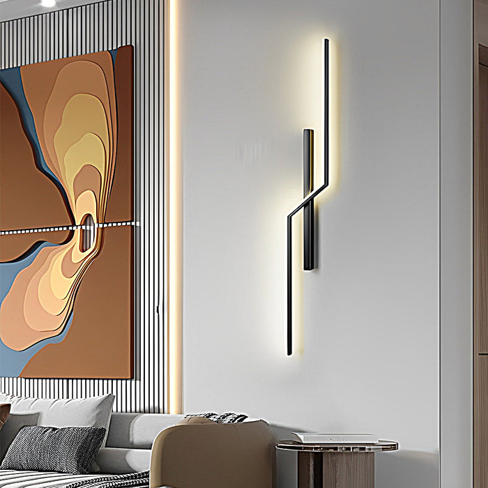 Vertical modern linear wall sconce with sculptural design used as accent lighting in contemporary living room.