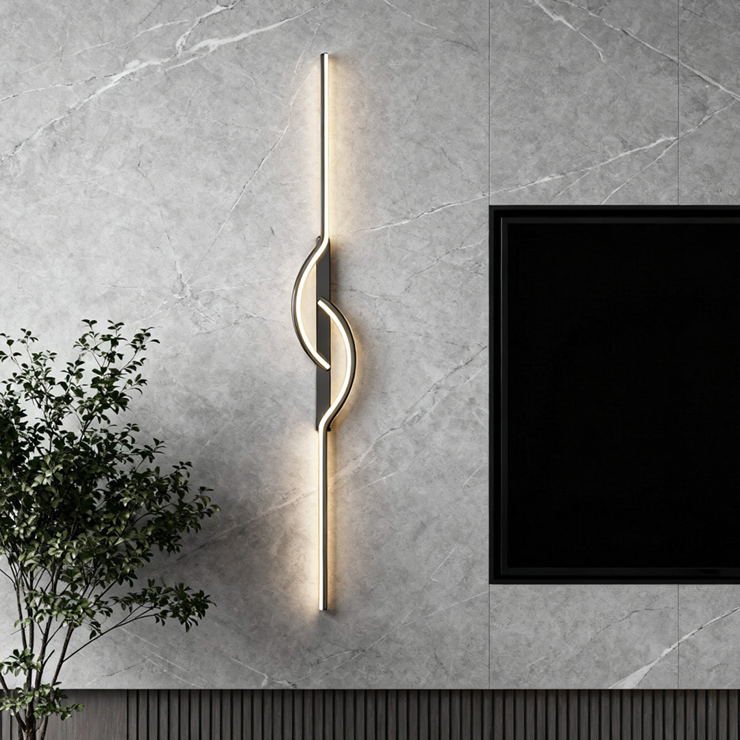 Modern linear wall sconce with sculptural LED design mounted on a textured gray wall.