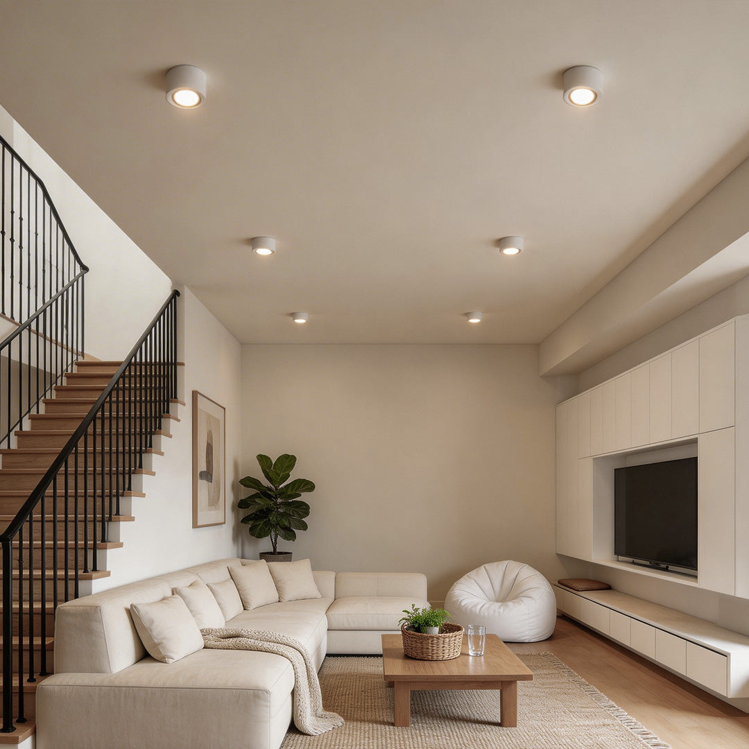 Modern living room with surface mounted can lights illuminating the space evenly.