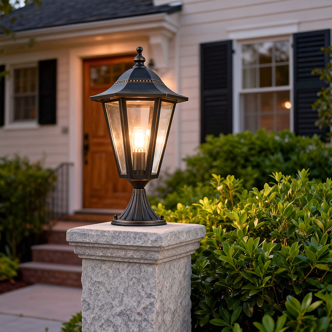 Modern main gate pillar light providing soft illumination for a driveway entrance at night.