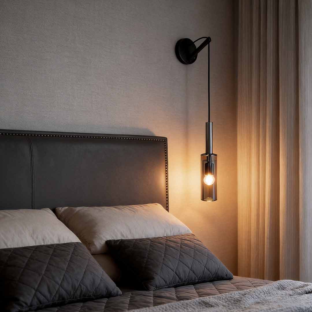 Modern minimalist bedside hanging wall lamp with smoke gray glass shade in a cozy bedroom.