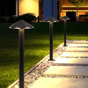 Modern black metal pathway lights with mushroom cap design, illuminating a stone path beside a grassy lawn at night.
