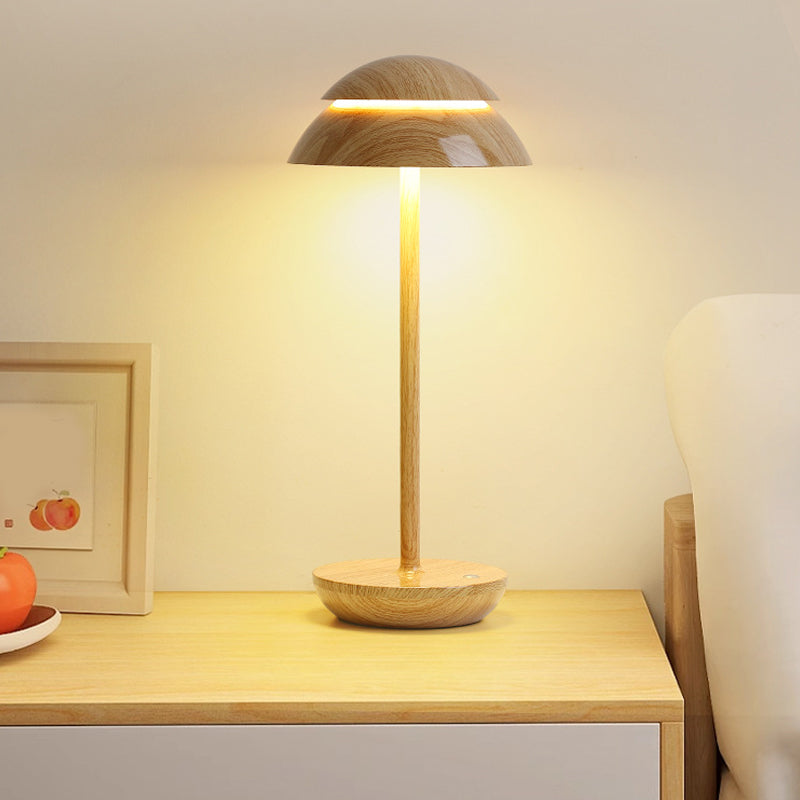 Modern mushroom table lamp illuminating a pair of lamps on a wooden table.