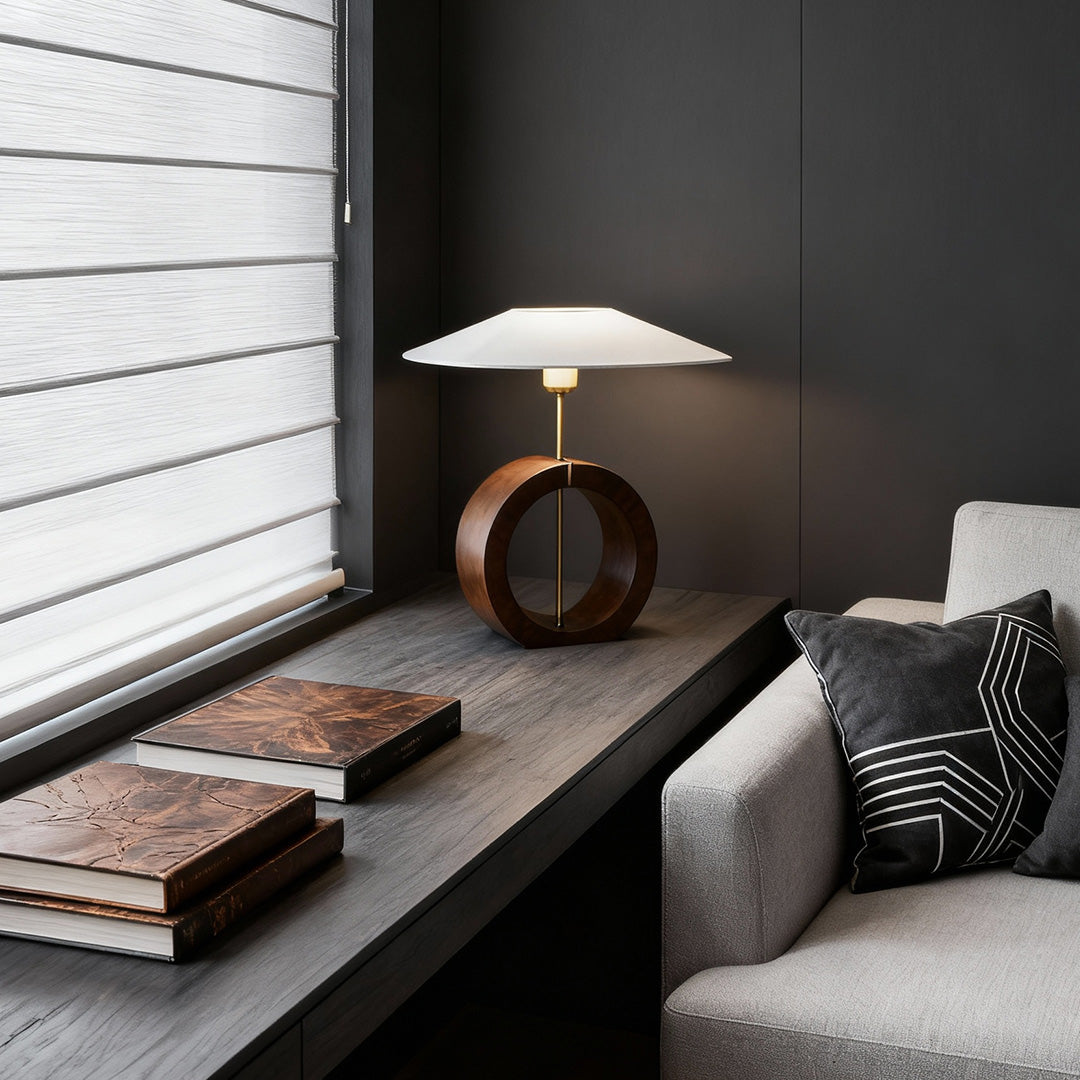 Ring natural wood table lamp on contemporary art-inspired desk space.