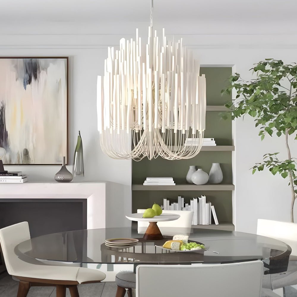 Modern organic stick chandelier above a round dining table, complementing the minimalist interior design.