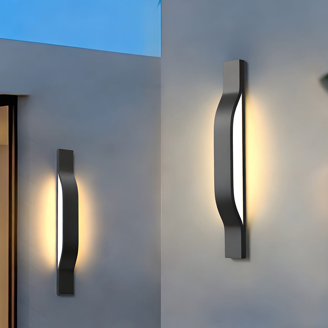 Modern outdoor exterior wall lights mounted on a white exterior wall creating warm evening illumination.