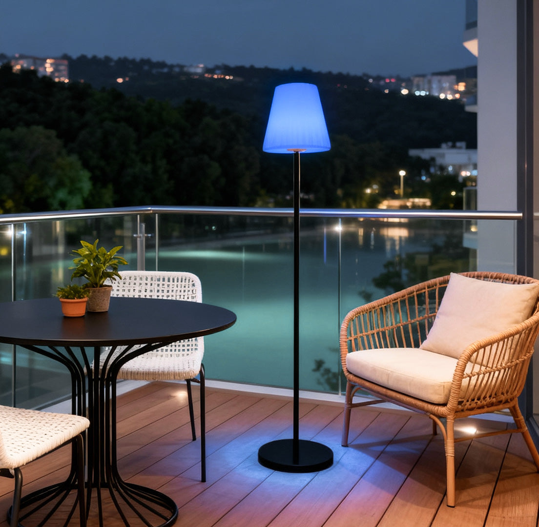 Modern outdoor floor lamp with a blue shade, lighting up a balcony with a scenic nighttime view.
