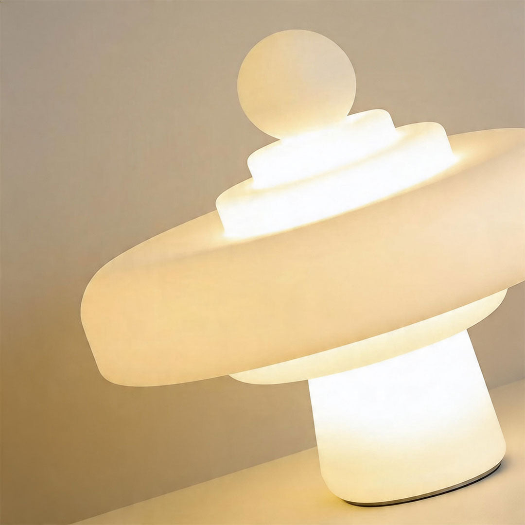 Close-up detail of modern outdoor floor lamps showing layered glowing diffuser and sculptural form.