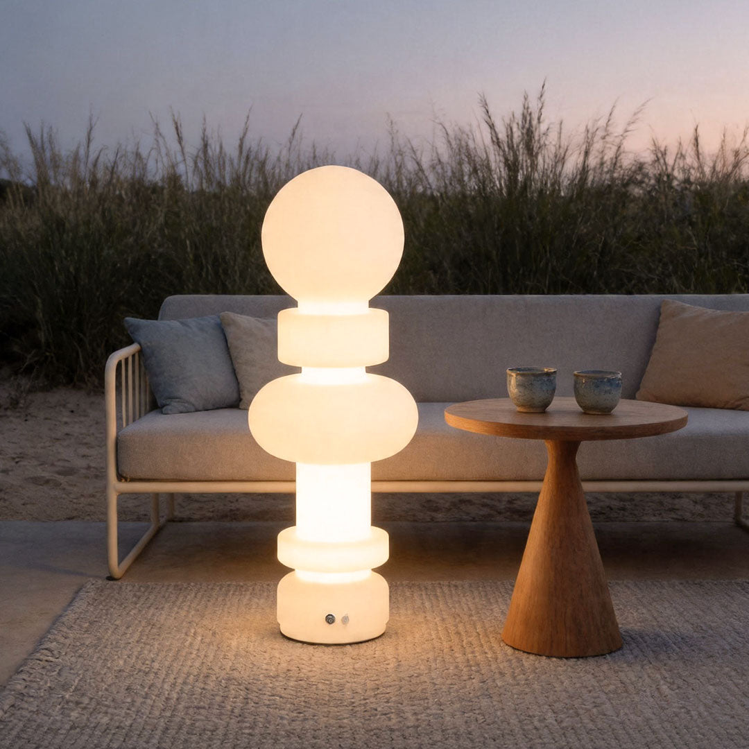 Modern outdoor floor lamps illuminating stylish patio lounge with warm decorative lighting effect.