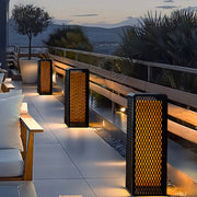 Modern outdoor lanterns aligned along a snowy pathway, creating warm and inviting winter lighting.