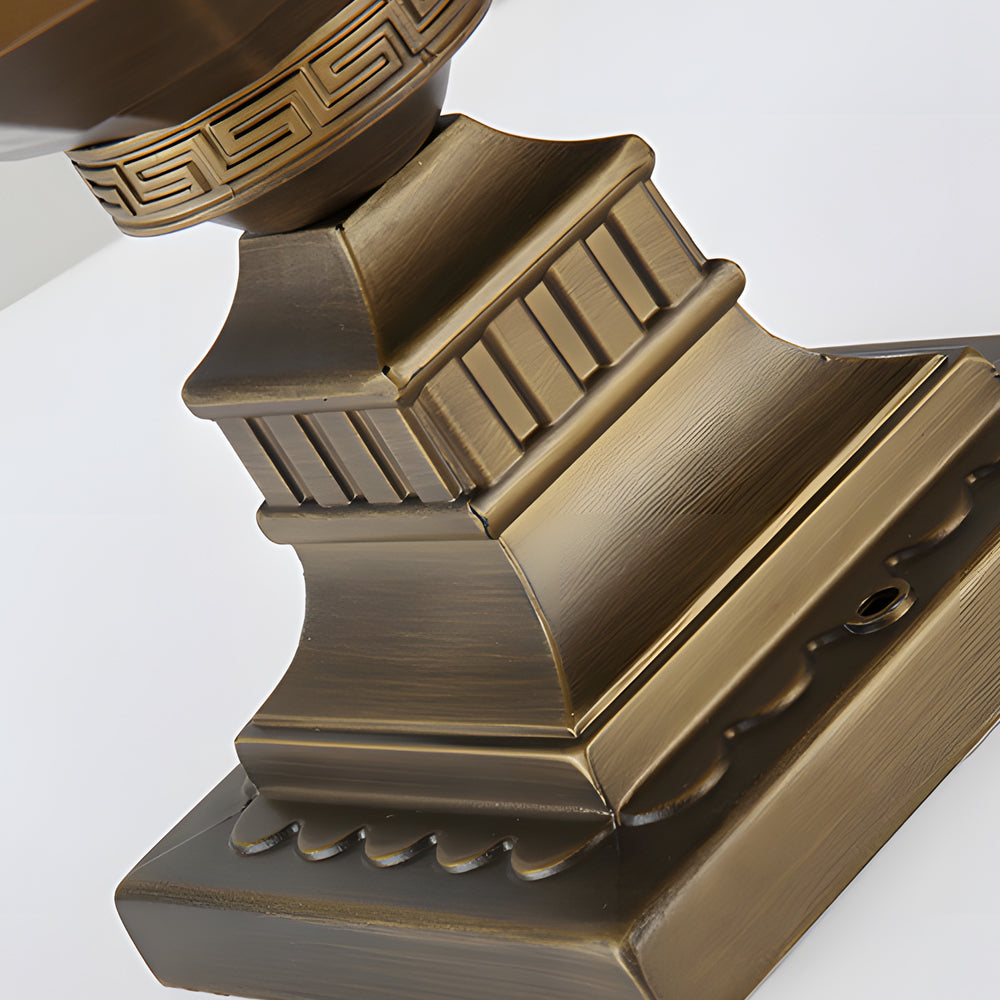 Modern outdoor pillar lights with a bronze finish, illuminating a garden pathway.