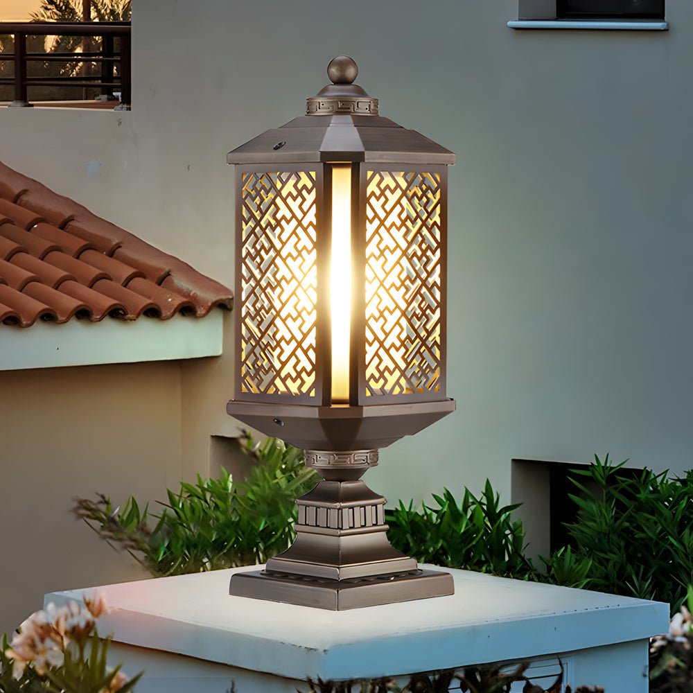 Modern outdoor pillar lights with a bronze finish, enhancing the ambiance of a lush garden.