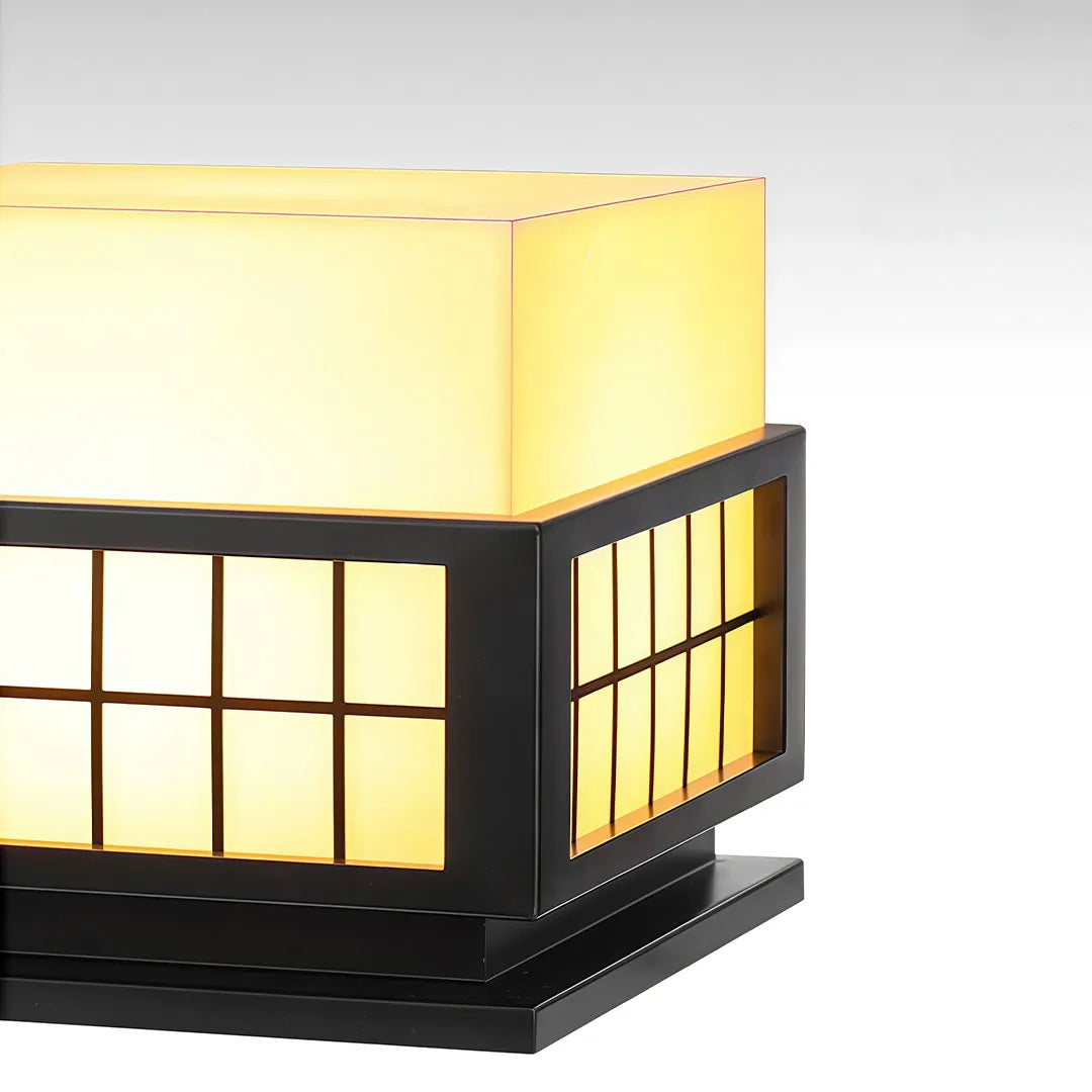 Close-up of modern outdoor pillar lights showing the frosted diffuser and black metal frame.