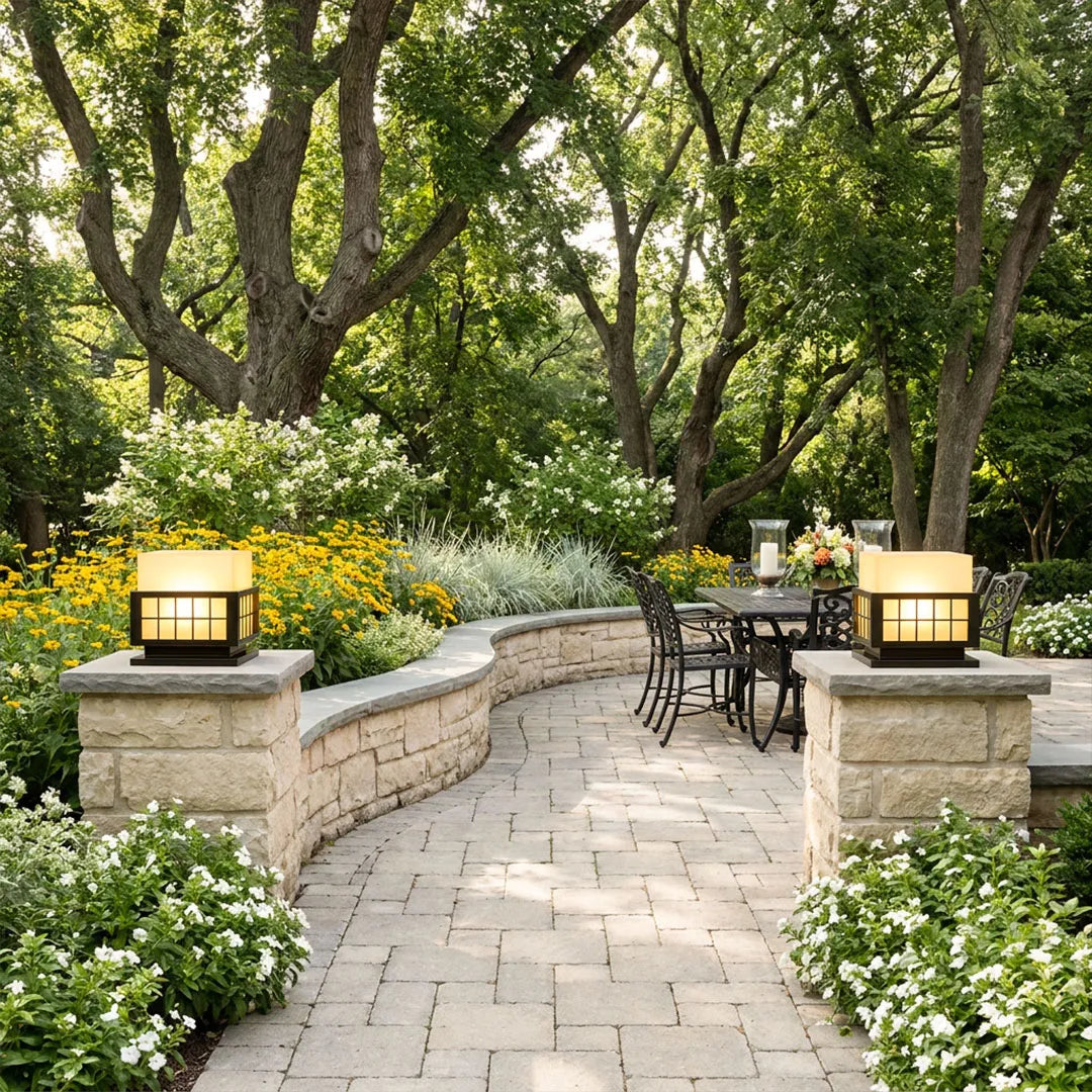 Modern outdoor pillar lights illuminating a garden pathway with elegant stone pillar installation.